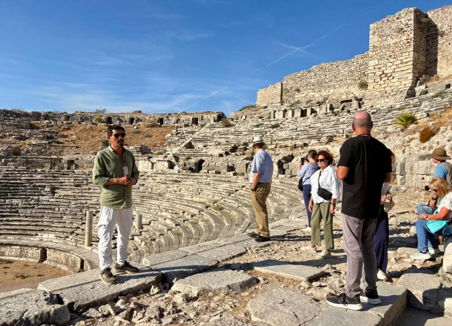 Guide speaking with a group among ancient stone seating